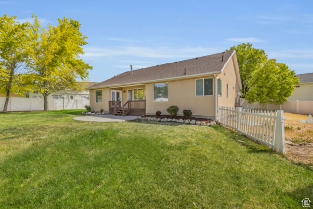 Rear view of house featuring a patio area and a lawn