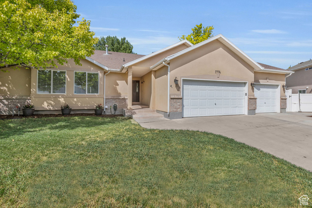 Ranch-style home with a garage and a front yard