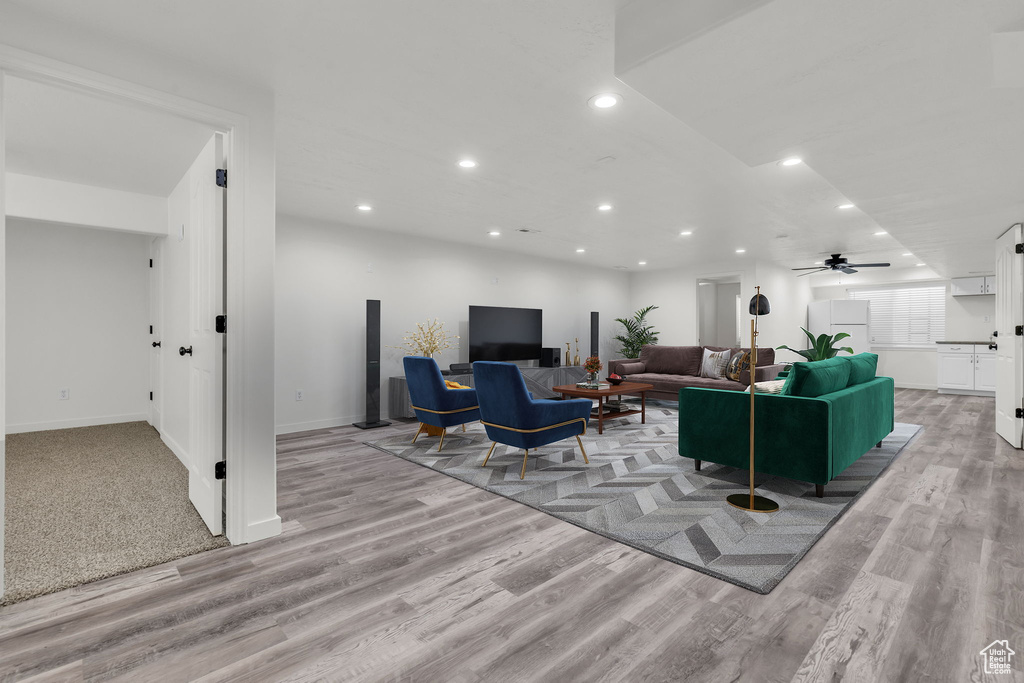 Carpeted living room featuring ceiling fan