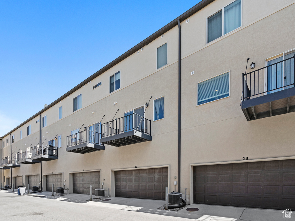 View of property with a garage and central AC