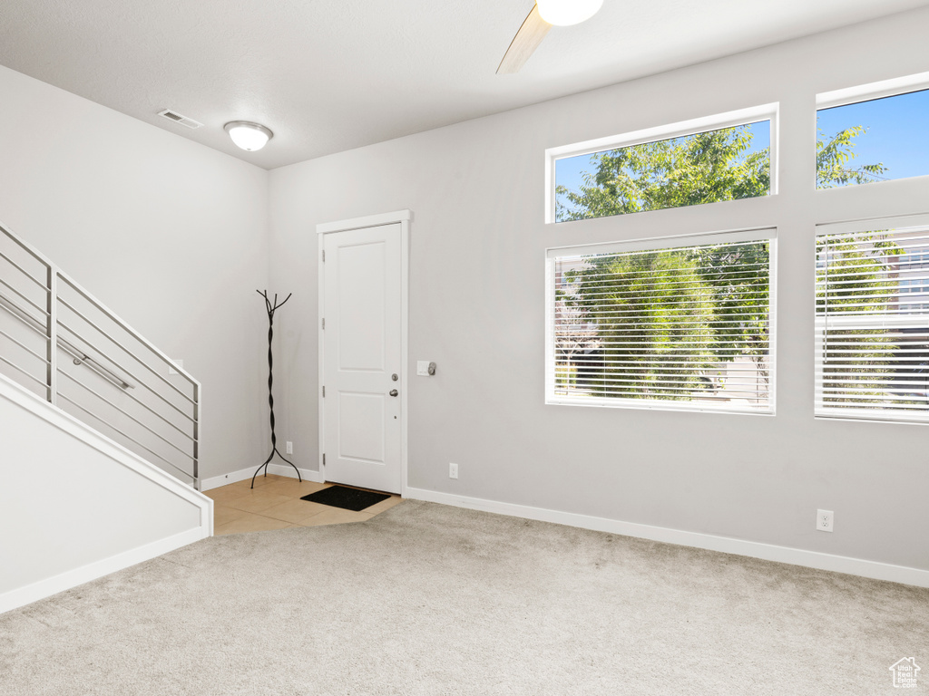 Carpeted entrance foyer featuring a wealth of natural light and ceiling fan