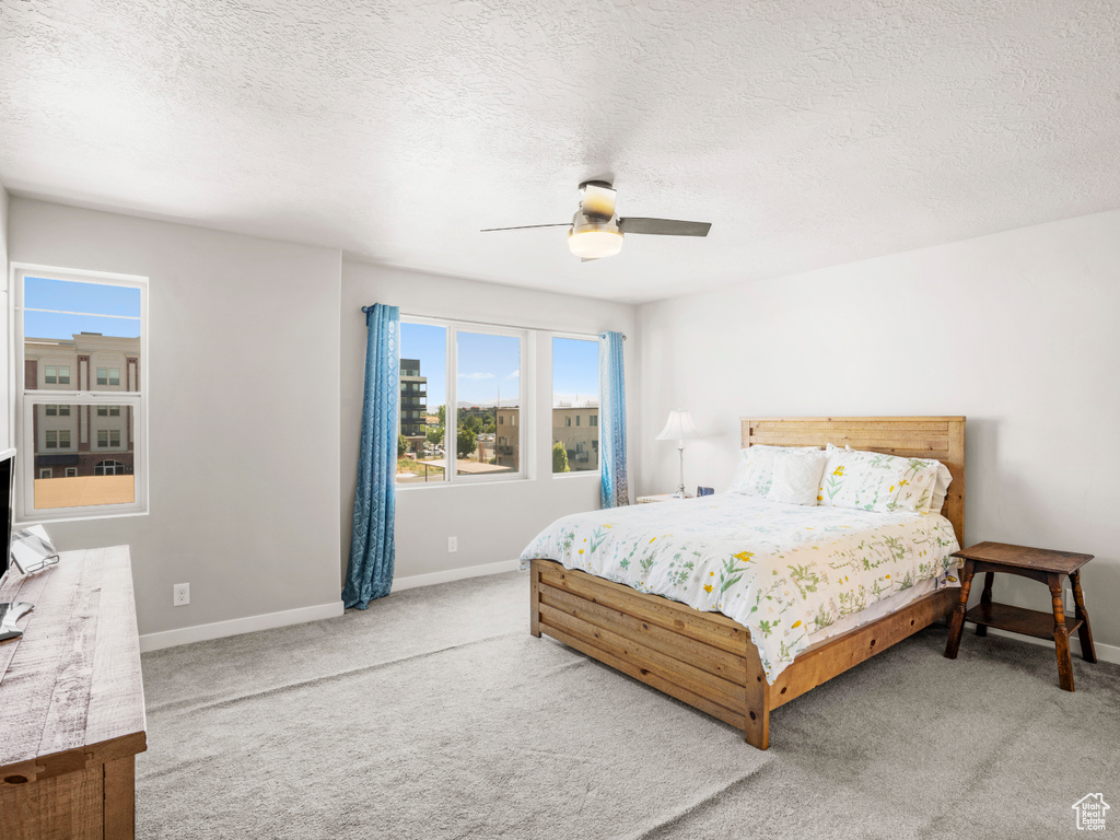 Bedroom featuring carpet floors, a textured ceiling, and ceiling fan