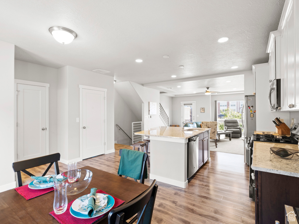 Dining space with sink, light hardwood / wood-style flooring, and ceiling fan