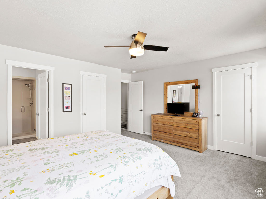 Bedroom featuring ensuite bath, ceiling fan, and light colored carpet