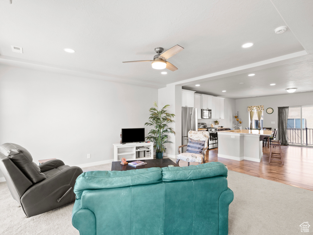 Living room featuring light hardwood / wood-style floors, sink, and ceiling fan