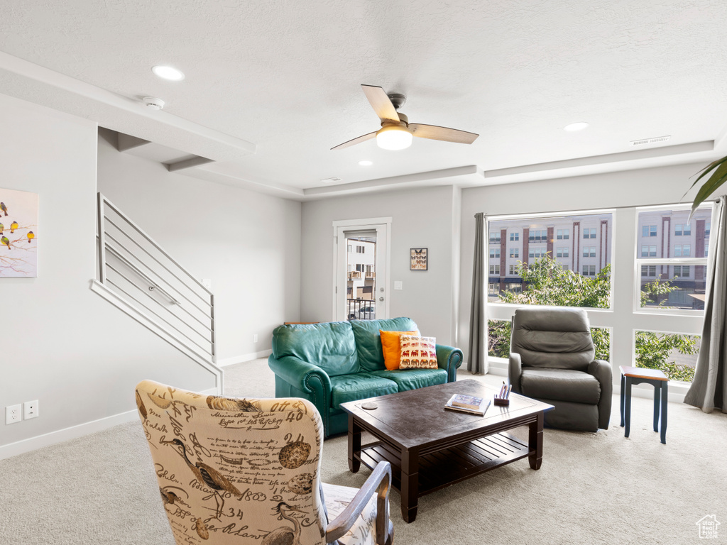 Living room with light colored carpet and ceiling fan