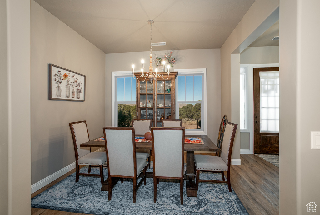 Dining room with an inviting chandelier and hardwood / wood-style flooring