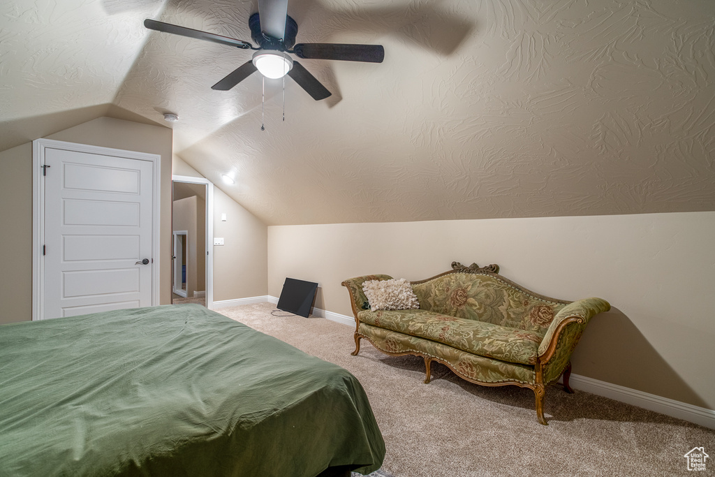 Bedroom with ceiling fan, carpet floors, and vaulted ceiling