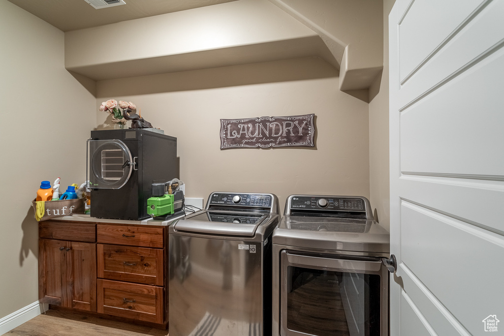 Laundry area featuring light wood-type flooring and separate washer and dryer