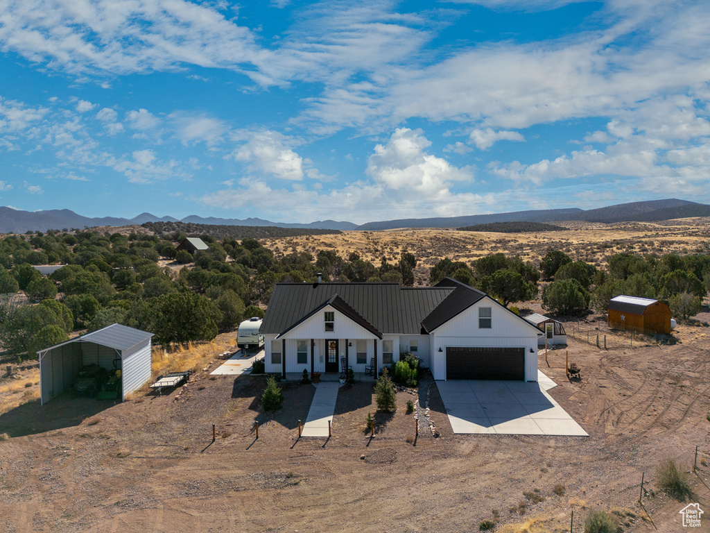 View of front of property featuring a carport, a mountain view, and covered porch