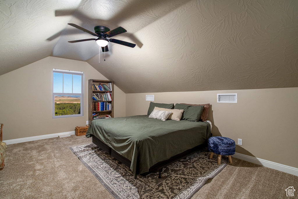 Bedroom featuring ceiling fan, lofted ceiling, and carpet