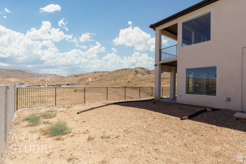 View of yard featuring a balcony and a mountain view