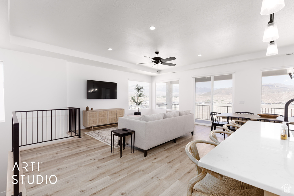 Living room featuring a mountain view, light hardwood / wood-style flooring, and ceiling fan