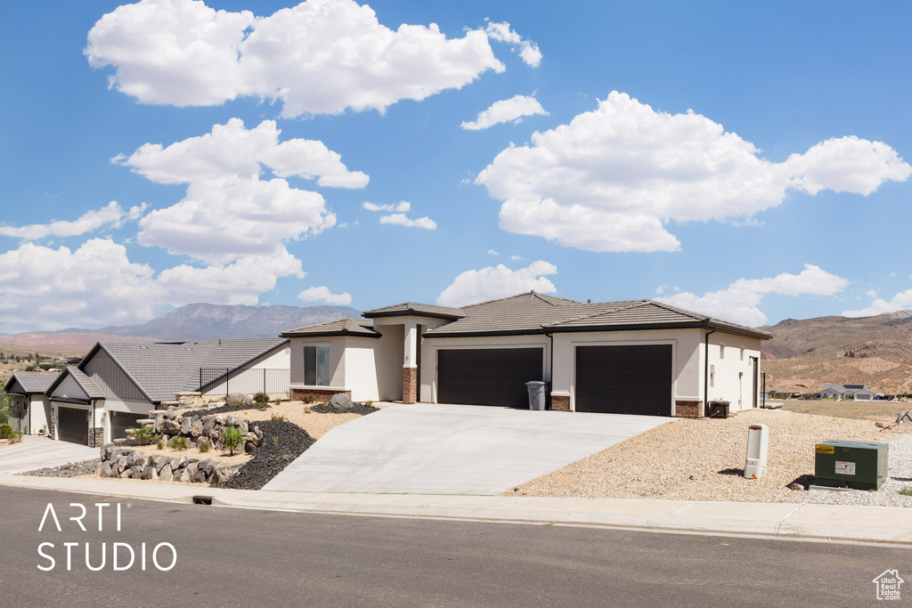 View of front of house with a mountain view and a garage