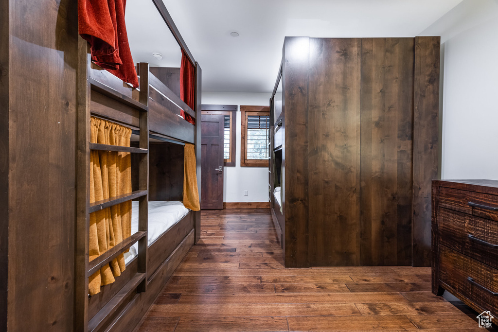 Spacious closet with dark hardwood / wood-style floors