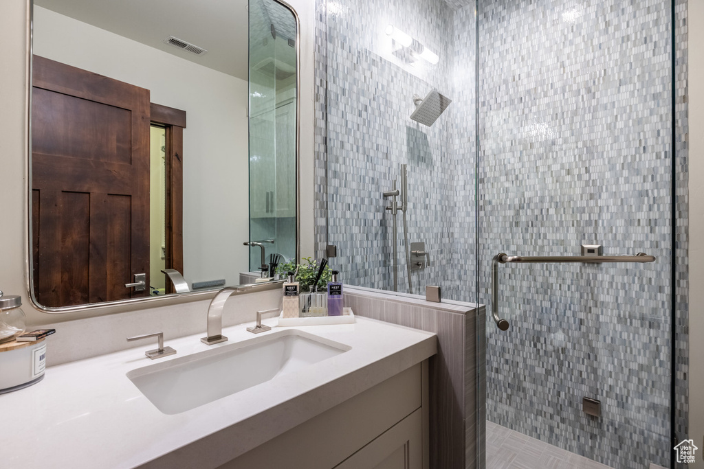 Bathroom with a shower with shower door and vanity