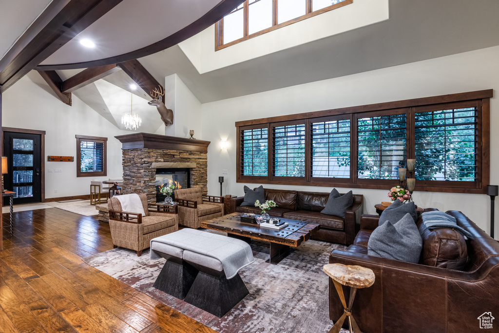 Living room with beam ceiling, wood-type flooring, a fireplace, and high vaulted ceiling