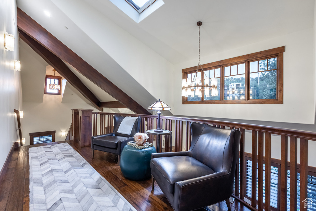 Bedroom with dark wood-type flooring, lofted ceiling with skylight, and a chandelier