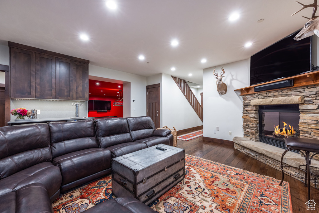 Living room with a fireplace and dark wood-type flooring