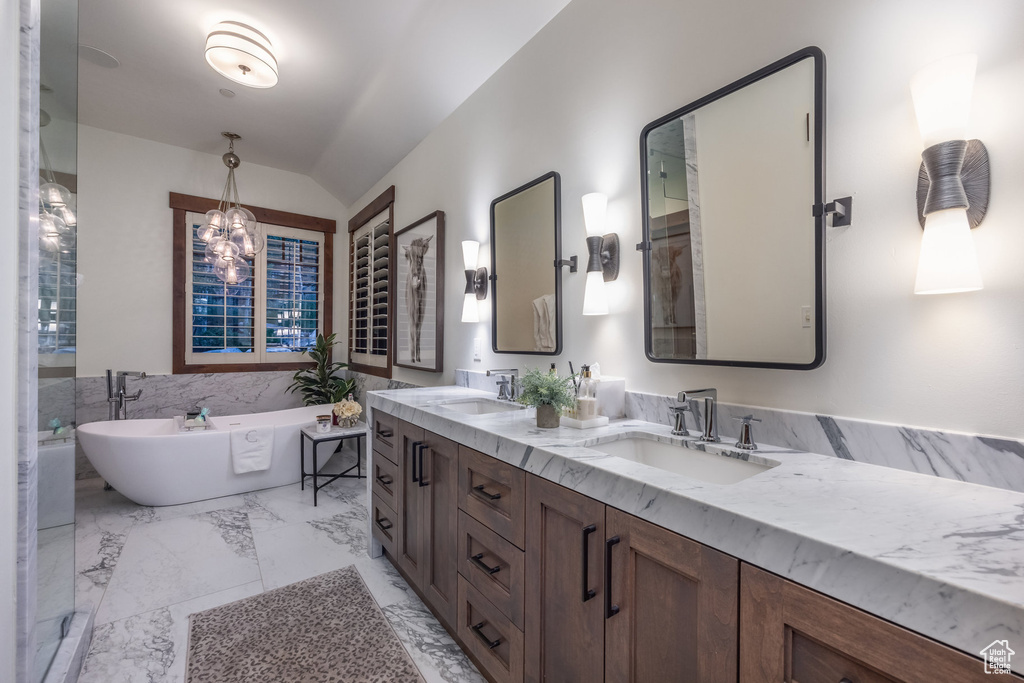 Bathroom featuring dual vanity, a tub to relax in, and tile patterned floors