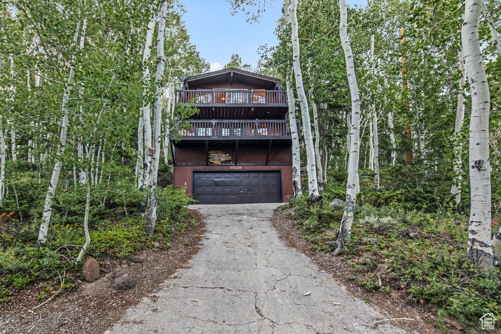 Front of property featuring a garage and a balcony