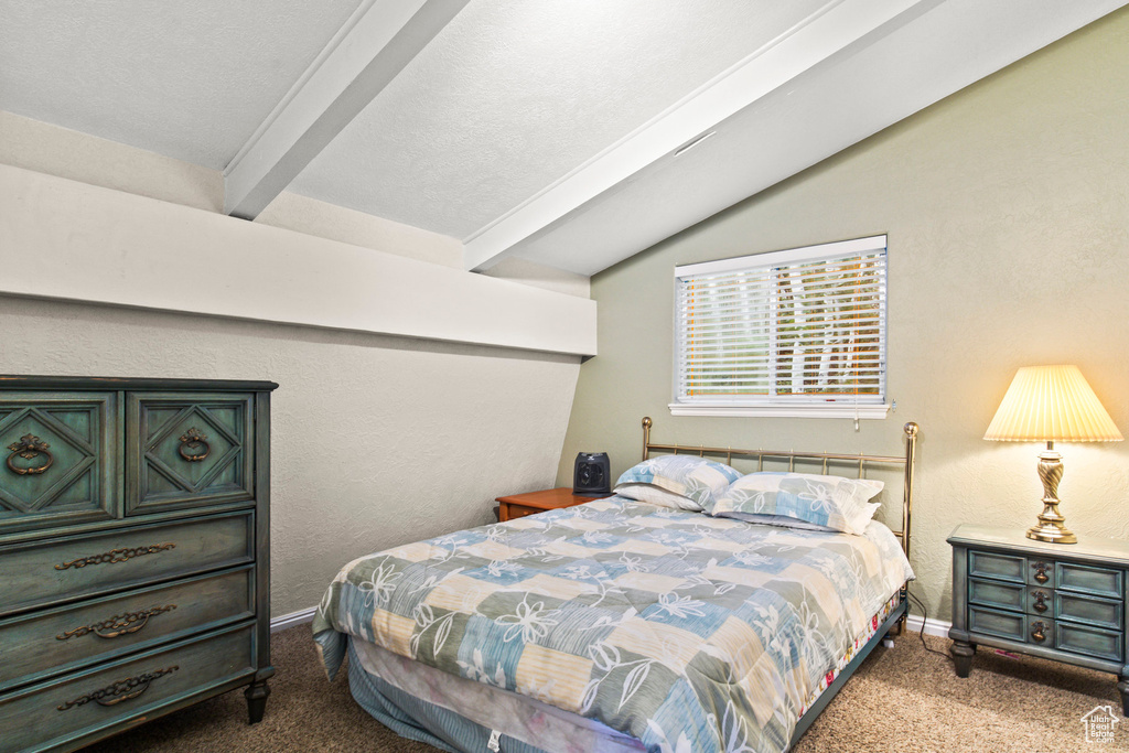 Bedroom with carpet floors, a textured ceiling, and lofted ceiling with beams