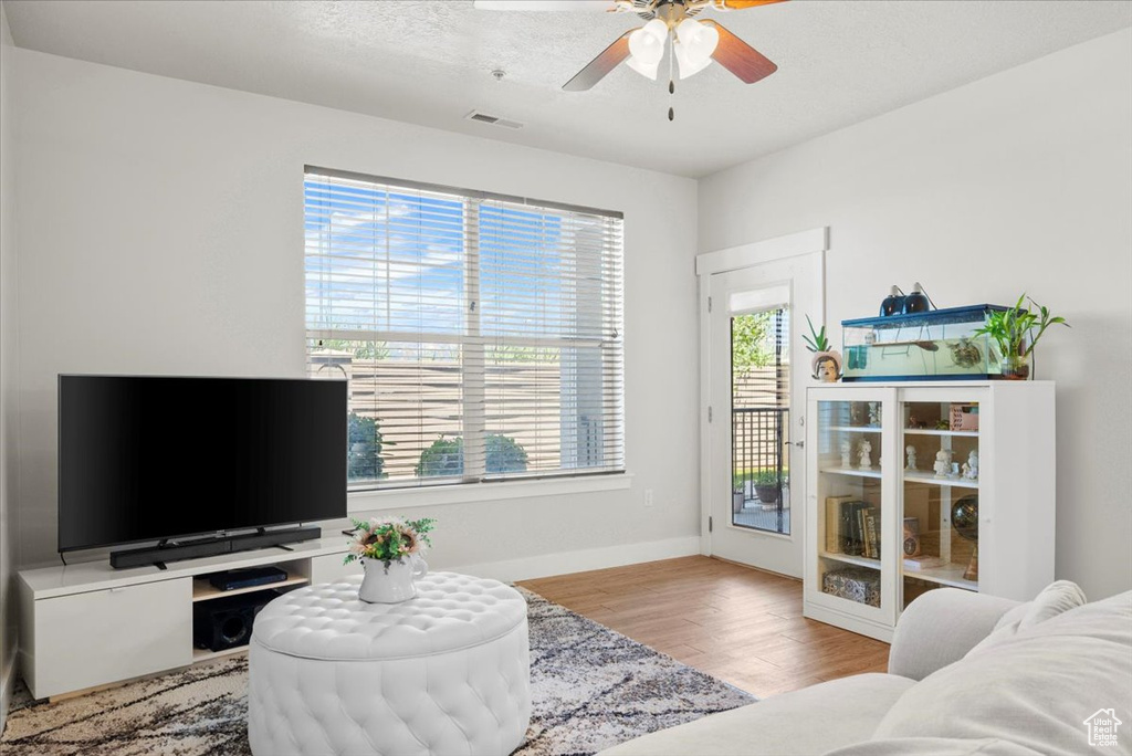 Living room featuring ceiling fan and light hardwood / wood-style floors