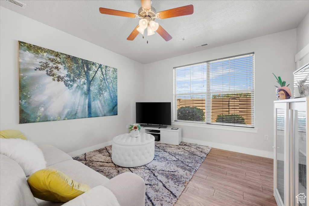 Living room featuring plenty of natural light, hardwood / wood-style flooring, and ceiling fan