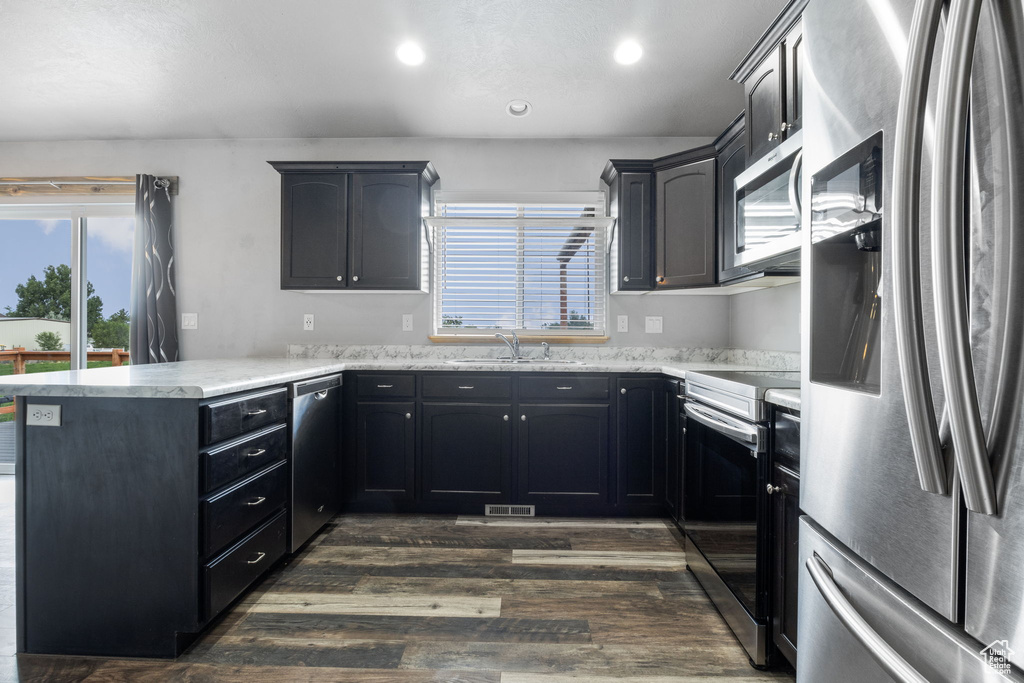 Kitchen featuring sink, dark wood-type flooring, kitchen peninsula, and stainless steel appliances