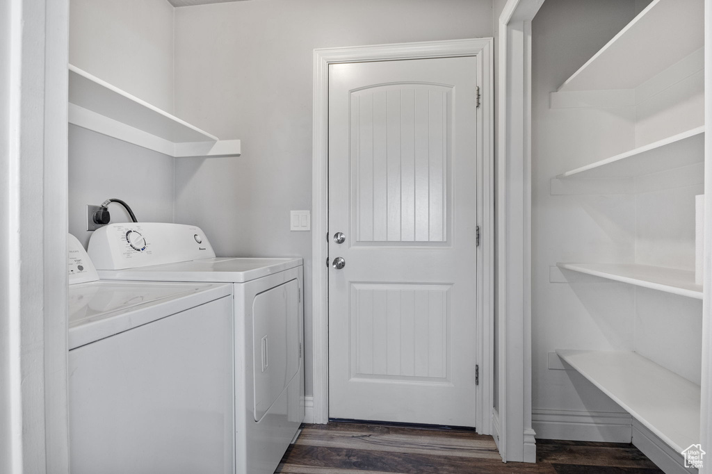 Washroom with dark hardwood / wood-style floors and independent washer and dryer