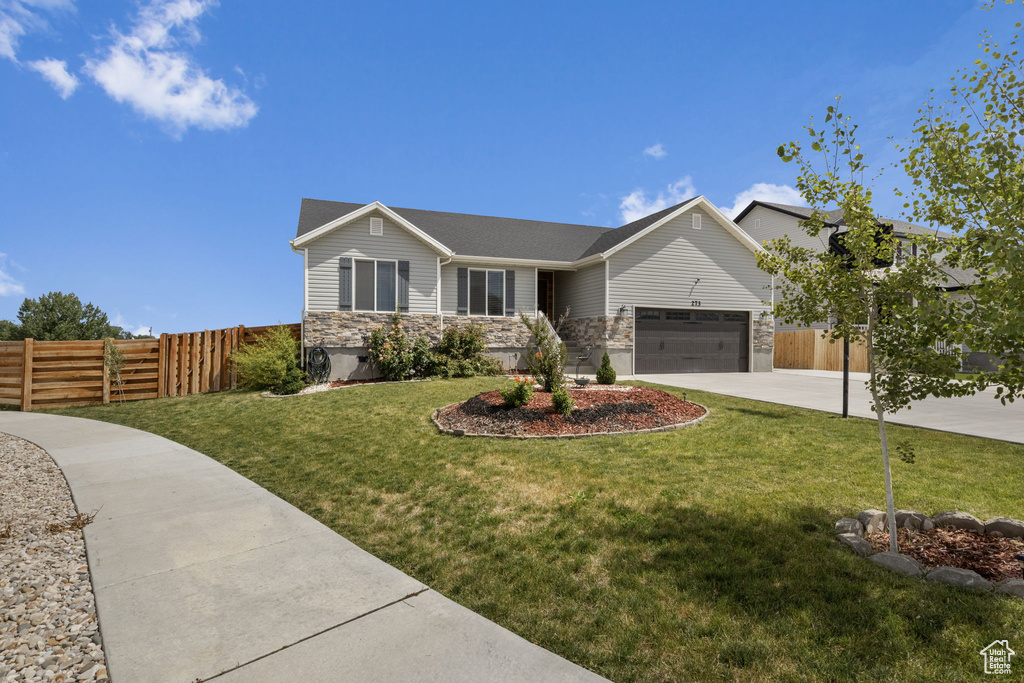 View of front of home featuring a garage and a front yard