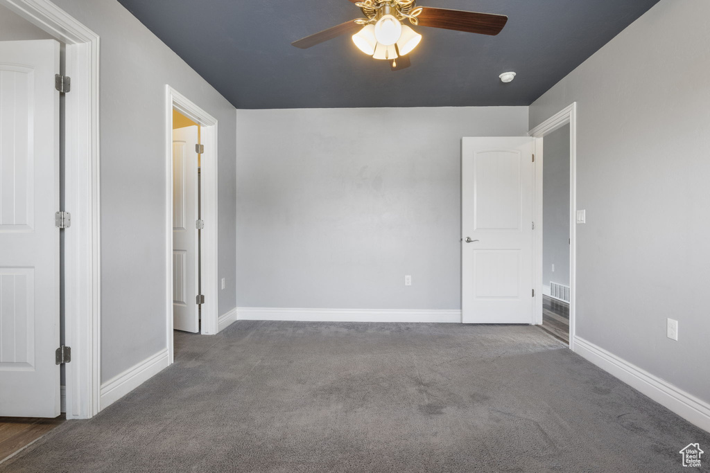 Carpeted spare room with ceiling fan