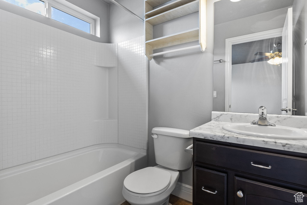 Full bathroom with vanity, tiled shower / bath, and toilet