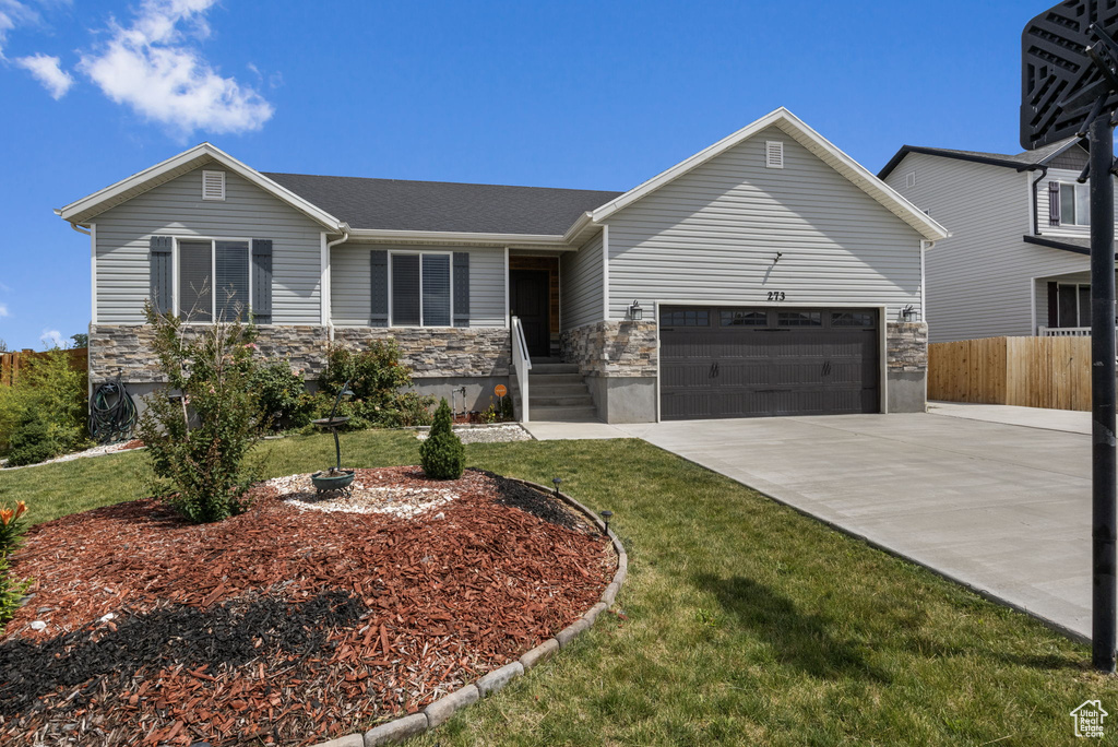 View of front of property with a garage and a front yard