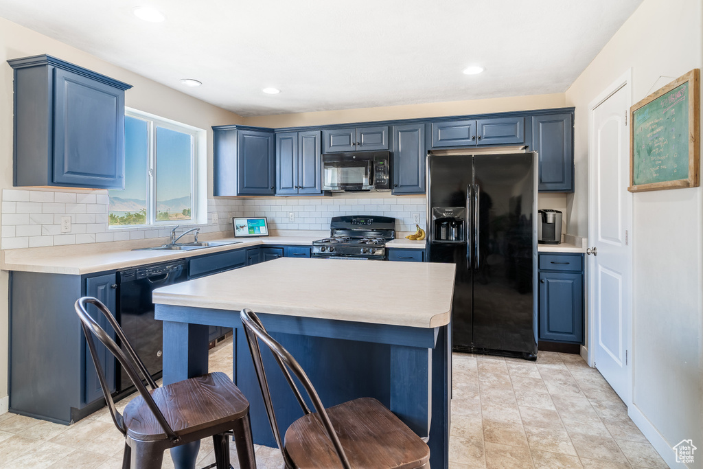 Kitchen featuring black appliances, light tile patterned floors, and backsplash