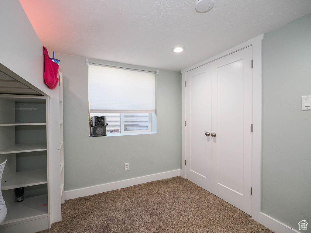 Unfurnished bedroom featuring dark carpet