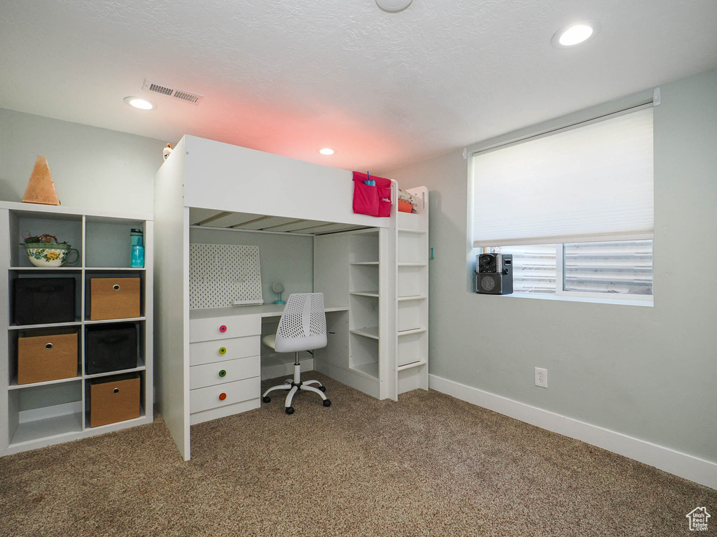 Interior space with carpet and a textured ceiling