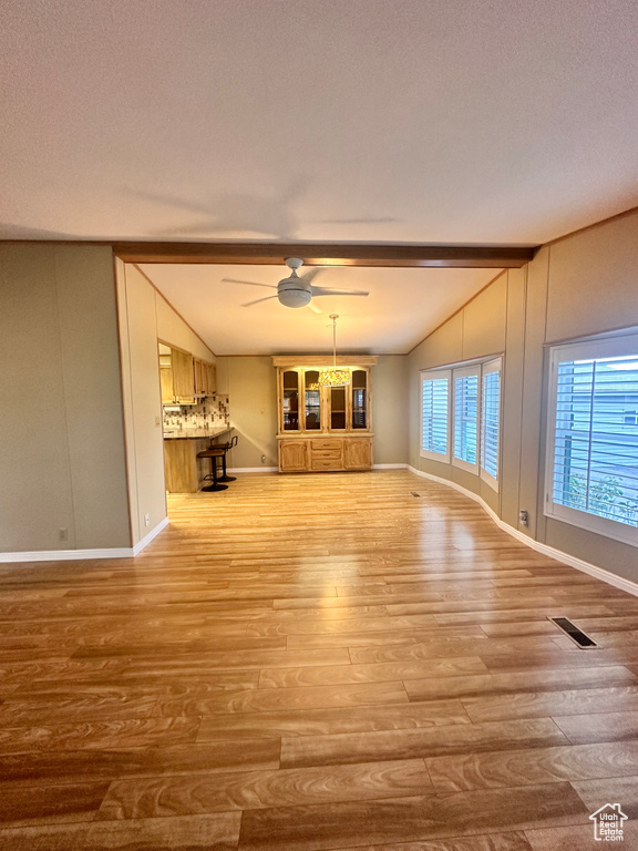 Unfurnished living room featuring lofted ceiling, a textured ceiling, ceiling fan, and wood-type flooring