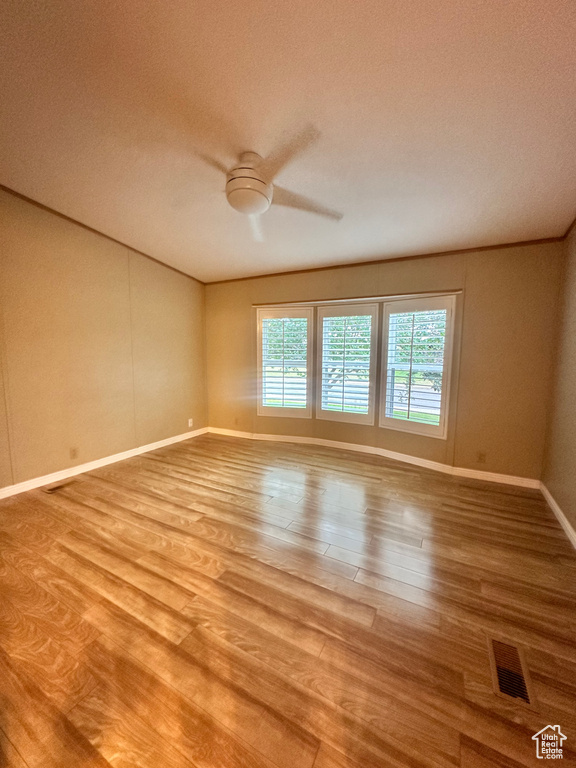 Empty room featuring ceiling fan and light hardwood / wood-style flooring