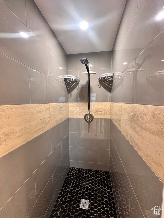 Bathroom featuring a tile shower and tile walls