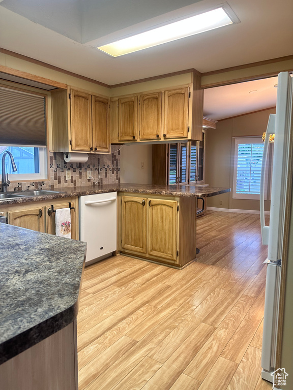 Kitchen with tasteful backsplash, stainless steel fridge, light hardwood / wood-style floors, lofted ceiling, and dishwasher