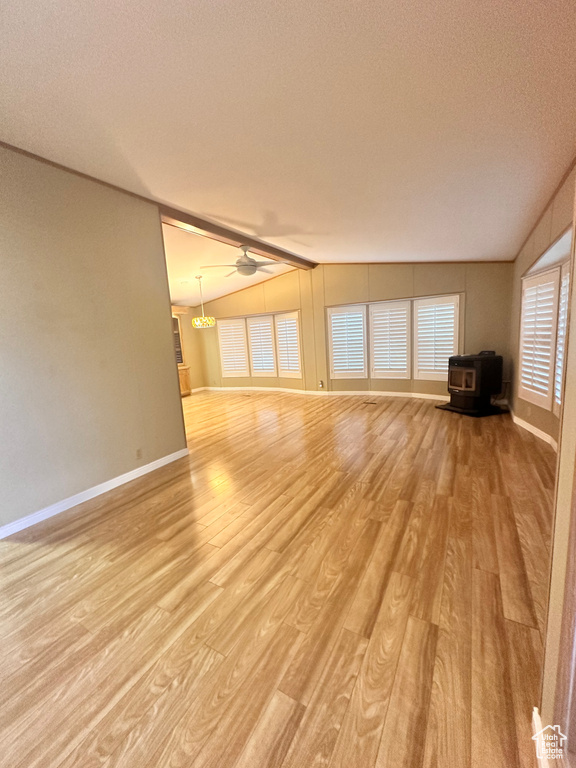 Unfurnished living room featuring a textured ceiling, light hardwood / wood-style flooring, lofted ceiling, and ceiling fan