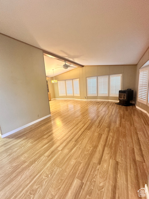 Unfurnished living room featuring a textured ceiling, ceiling fan, lofted ceiling, and light hardwood / wood-style floors