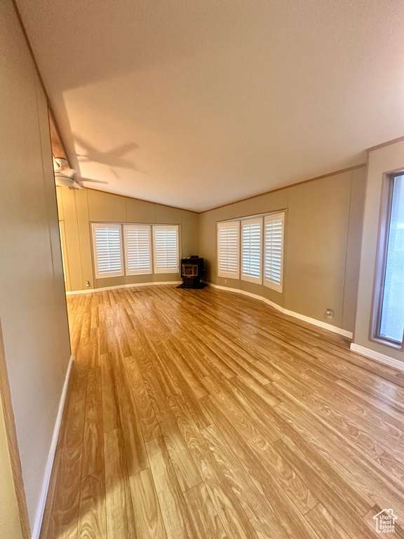 Unfurnished living room with light wood-type flooring, ceiling fan, and vaulted ceiling