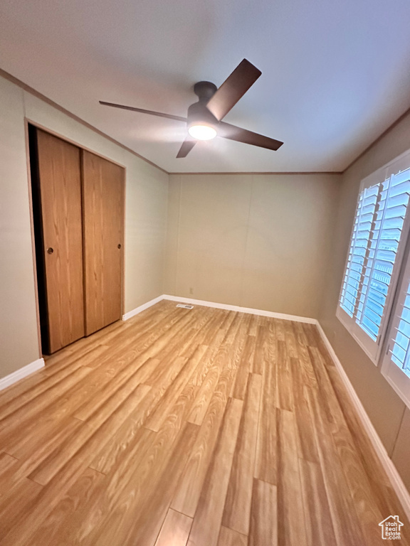 Unfurnished bedroom featuring ceiling fan, a closet, and light hardwood / wood-style floors