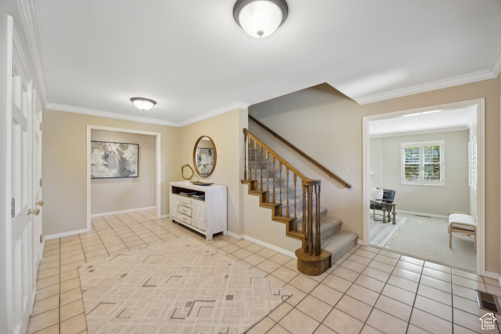 Entryway featuring light tile patterned flooring and ornamental molding