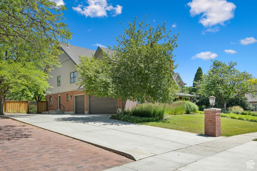 Obstructed view of property featuring a garage and a front lawn