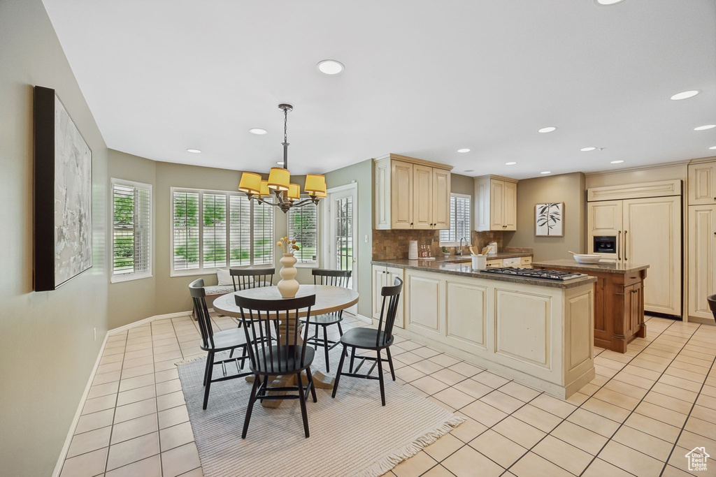 Kitchen featuring hanging light fixtures, backsplash, and light tile patterned floors