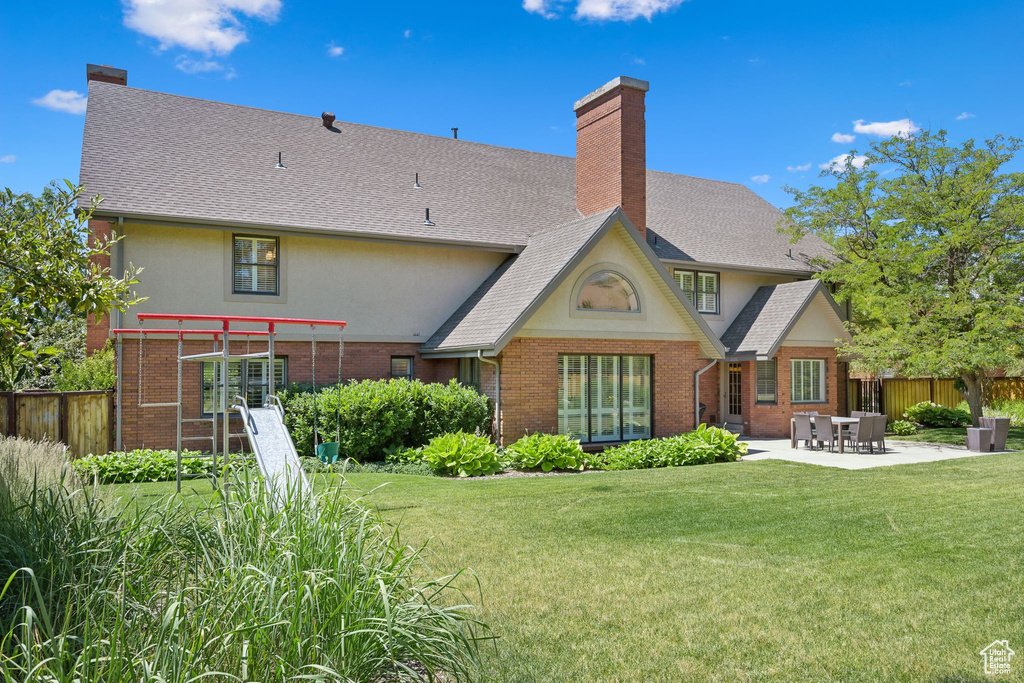 Back of house featuring a patio area and a lawn