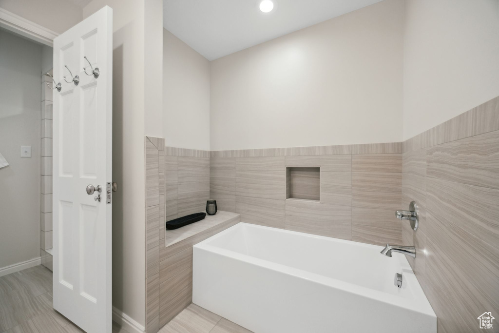 Bathroom with independent shower and bath and tile patterned floors